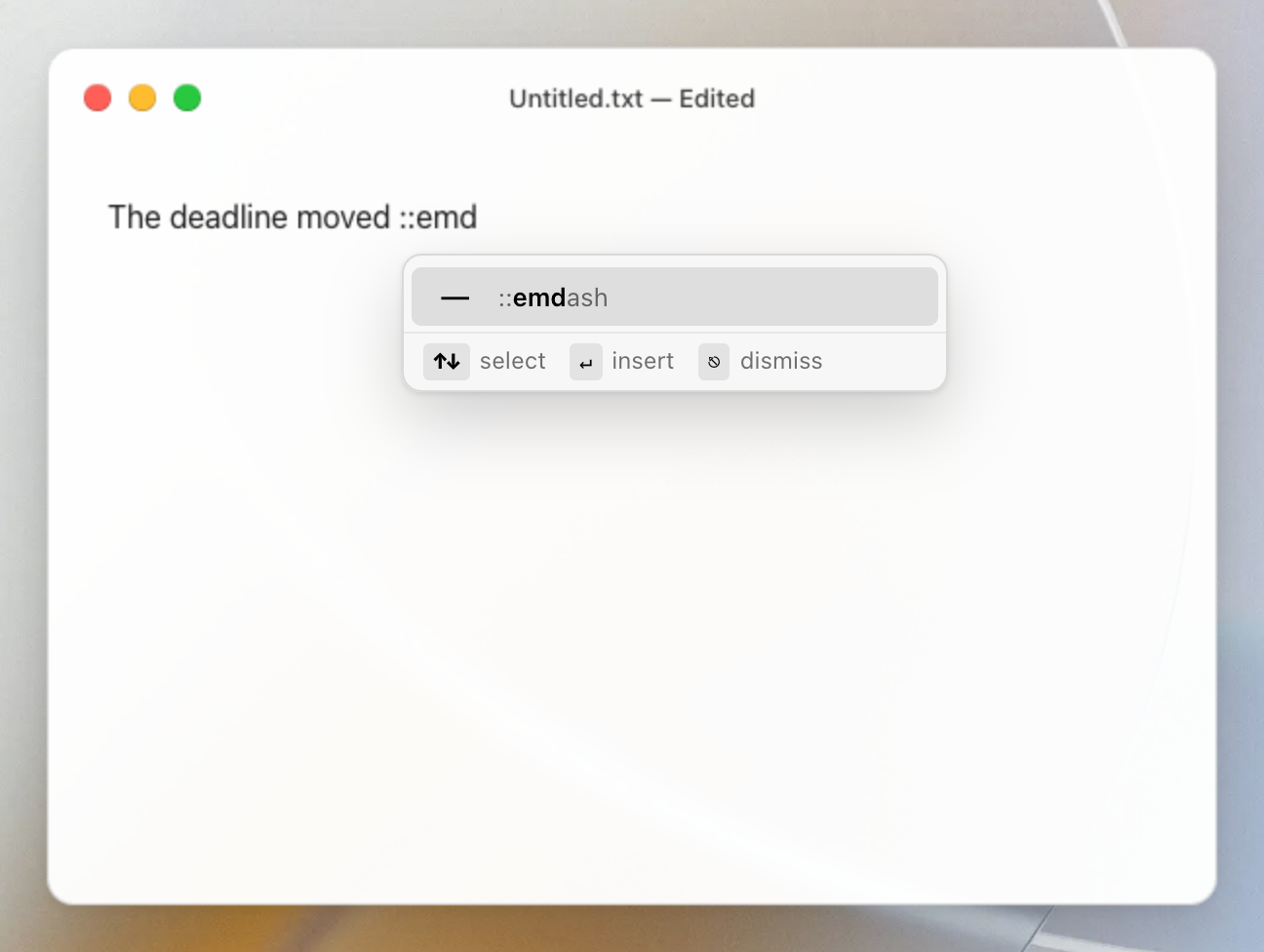 Mojito suggesting ::emdash while typing ::emd in TextEdit on macOS, inserting an em dash